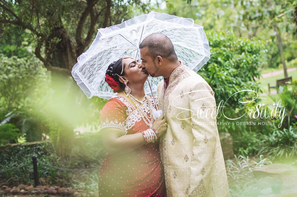 1 year wedding anniversary,durban botanical gardens,durban wedding photographers,red sari,sweetcr8ivity,elaine and aveen lutchman,will always be the 1 white rose amongst the red ones,love story,happiness,laughter,fun,creative,ring shot,couple goals,he always makes her smile,lace umbrella,creative photo shoot